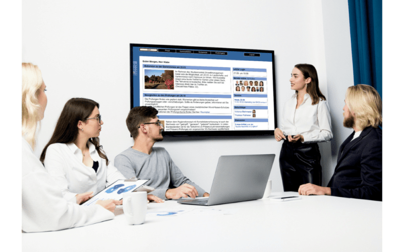 Ein Management-Team präsentiert Kennzahlen aus dem Campus-Management-System auf einem Bildschirm im Konferenzraum